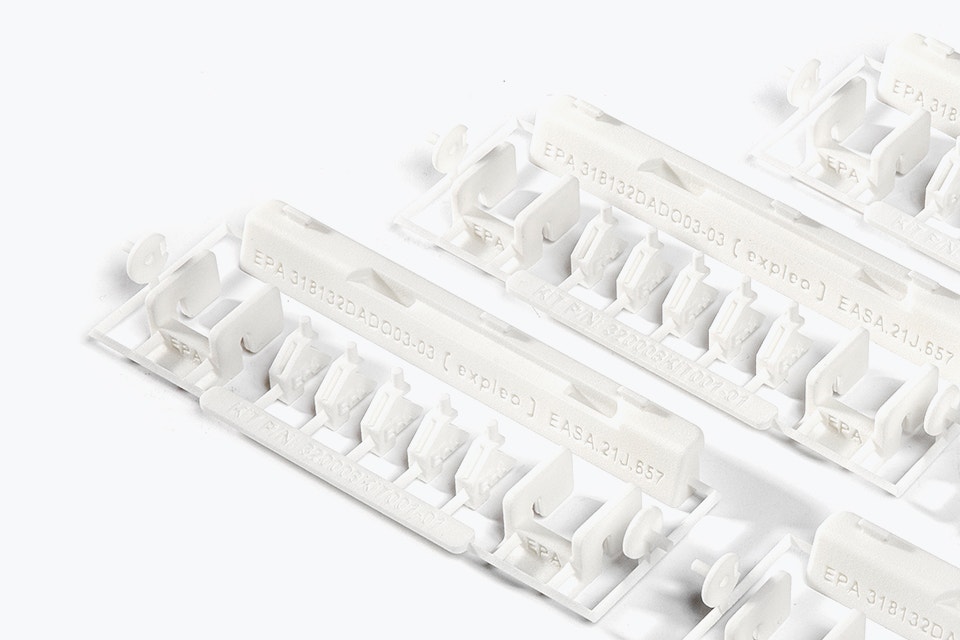 Une série de kits de réparation imprimés en 3D avec AESA 21.Labels de qualité J. Le kit contient des petites pièces en plastique blanc fabriquées en polyamide ignifugé, conçues par Expleo. Ces pièces sont utilisées pour remplacer les loquets couramment cassés sur les panneaux lambrissés des Boeing 737.
