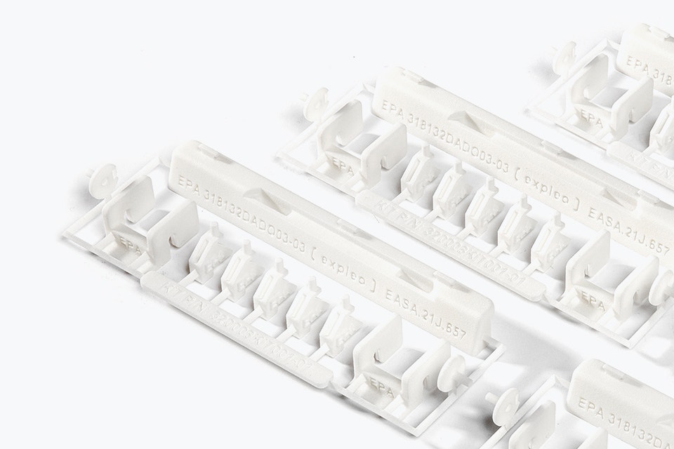 A series of 3D-printed repair kits with EASA 21.J quality labels. The kit contains small white plastic parts made of flame-retardant polyamide, designed by Expleo. These parts are used to replace commonly broken latches on Boeing 737 dado panels. 