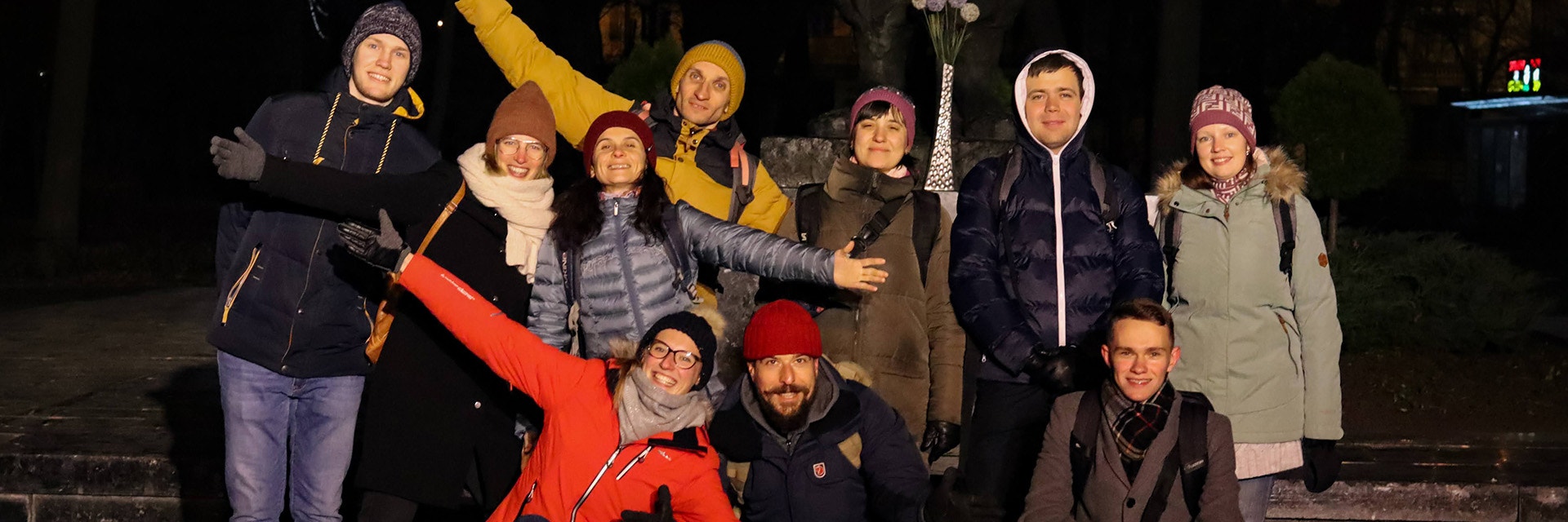 A group photo of the Enlight CMF team standing outside. They are smiling at the camera with their arms open.