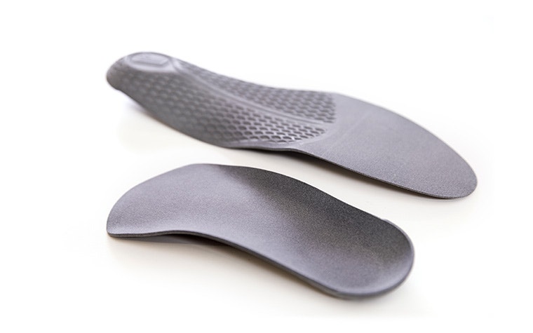 A pair of gray 3D-printed insoles made in PA 11 using Multi Jet Fusion.