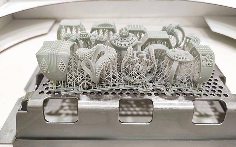 3D-printed jewelry on a build plate with support structures
