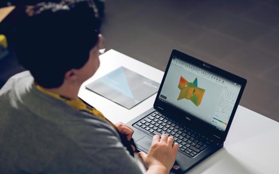 Woman using Magics on a laptop next to an informational brochure