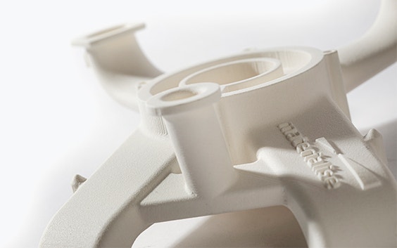 Close-up view of an off-white air duct with multiple curved openings, 3D printed in a halogen-free flame-retardant polyamide.