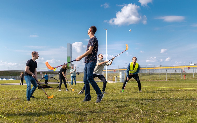 A group of people playing hockey on a sunny day