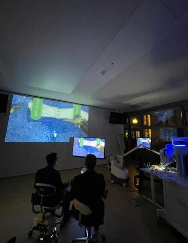 A surgeon and trainer using the Symani System and training board