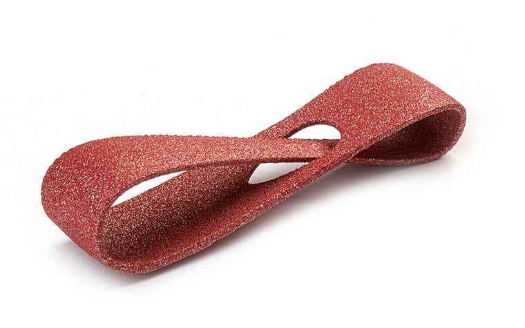 A glittering red 3D-printed loop made from PA-AF (aluminum filled) using laser sintering, with a color-dyed finish.