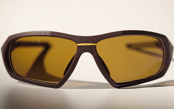 Pair of SEIKO Xchanger 3D-printed sports glasses with brown frame, yellow accents, and smoke-tinted lenses, seen from front