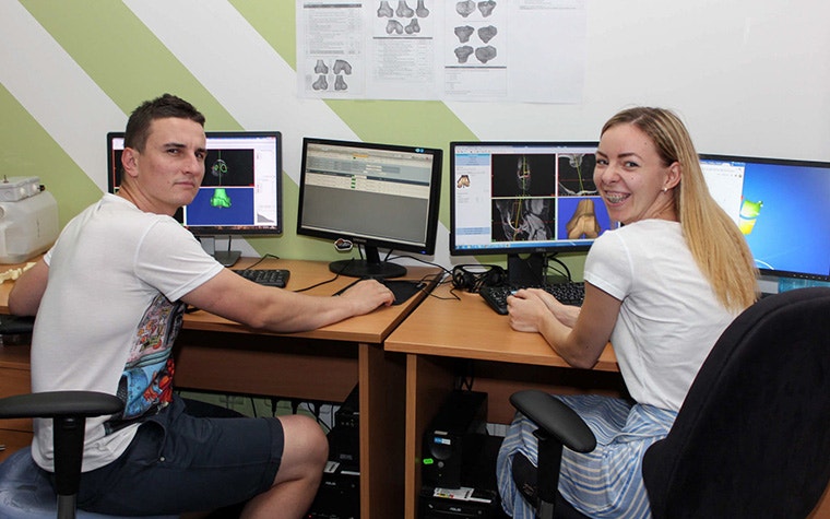 Two students at Materialise Ukraine using PROPLAN CMF™ software. They are looking toward the camera and smiling.