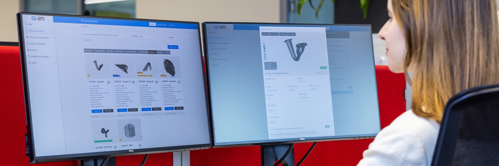 A woman looking at two computer screens showing 3D parts