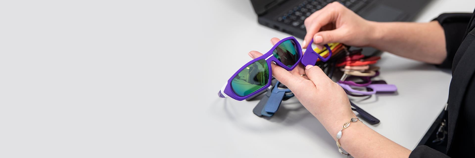 Person looking through eyewear color samples while holding 3D-printed sunglasses