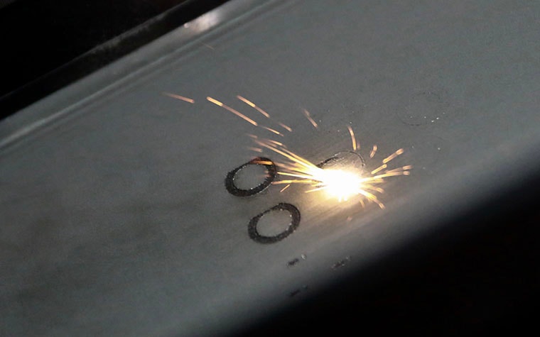 Laser hitting a metal powder bed to 3D print a circlular shape