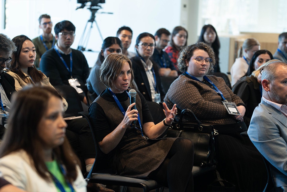 Group of 3D Printing in Hospitals Forum 2024 attendees sitting down, with one attendee holding a microphone to ask a question