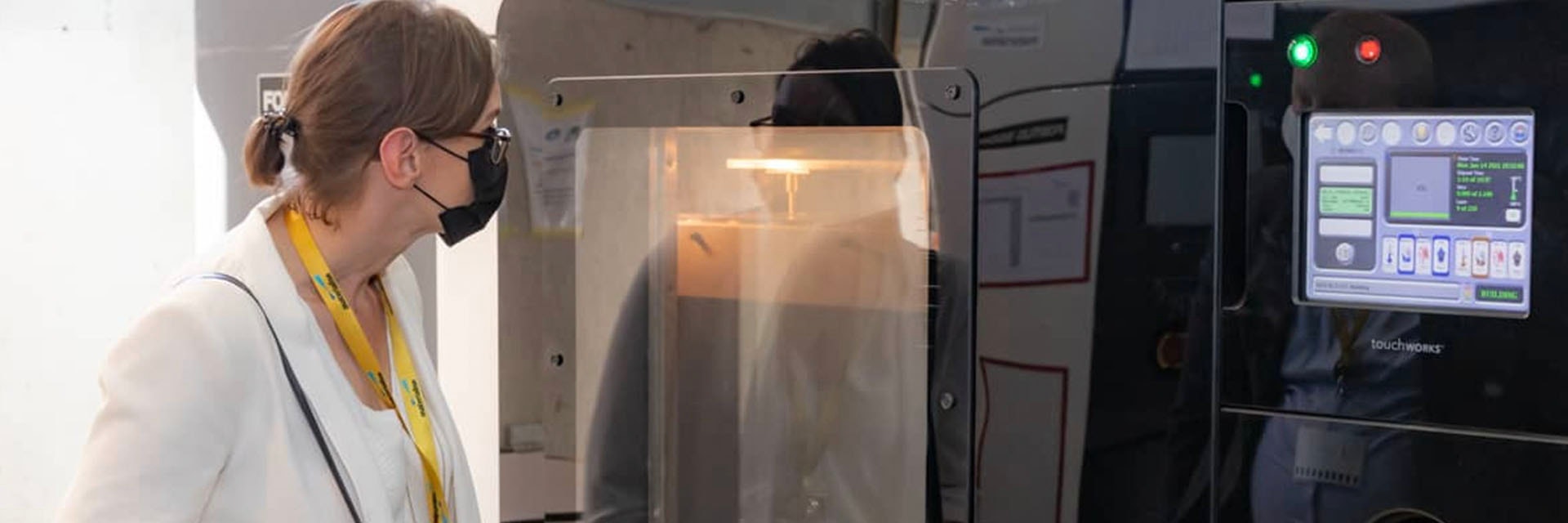 Woman looking into a 3D printer