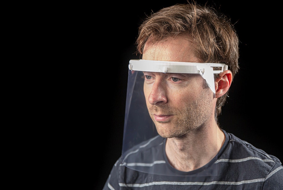 Ein Mann trägt einen durchsichtigen Gesichtsschutz mit einem 3D-gedruckten Aufsatz