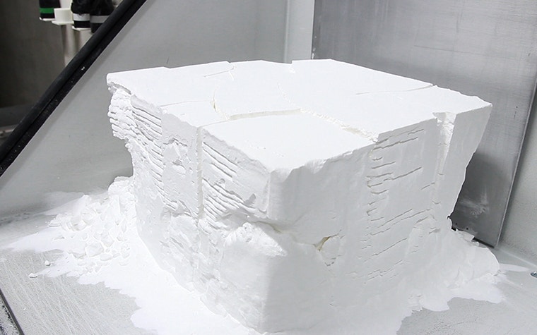 Weißes Pulverbett, das viele 3D-gedruckte Teile enthält