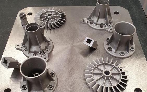 Various metal 3D-printed parts on a build plate
