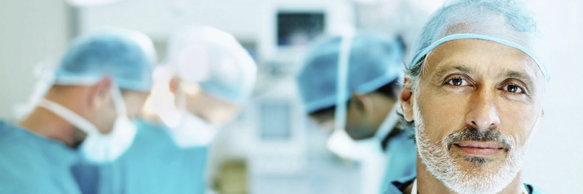 Surgeon standing in front a group of surgeons with their masks on