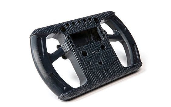 A black 3D-printed racing-style steering wheel made in Taurus using stereolithography.