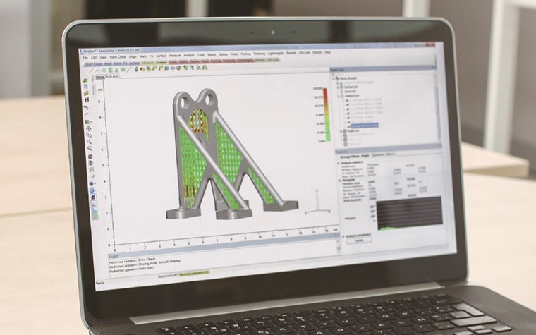 Laptop with Materialise 3-matic screen open, showing 3D representation of titanium aerospace part 