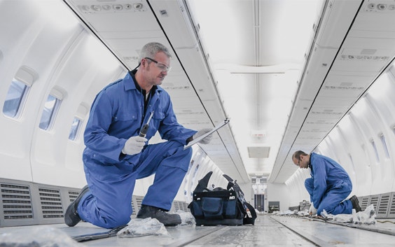 Aircraft engineers working on the interior of an 737 jet airplane