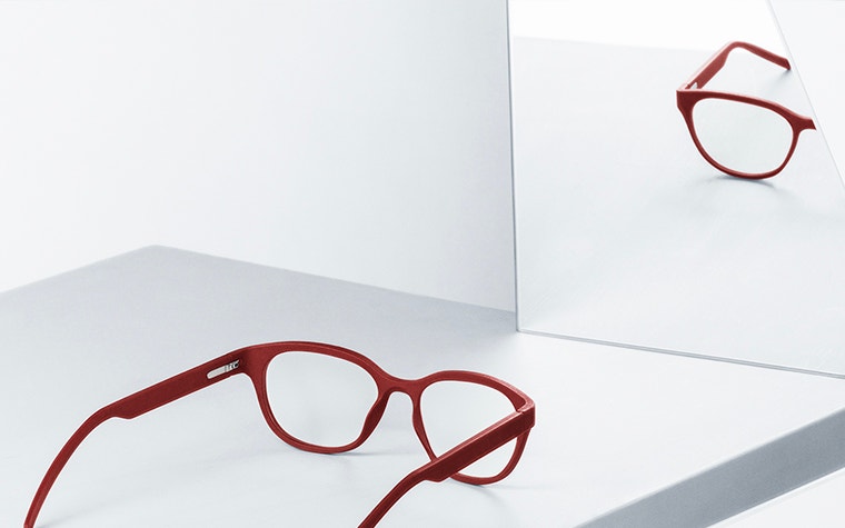 Rote Yuniku+Øgrüne Brille, die sich in einem Spiegel spiegelt