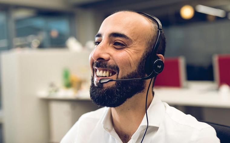 Customer support officer smiling with his headset on