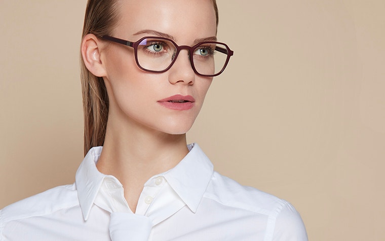 Close-up of female model wearing white, looking off camera, wearing dark eyewear from BAARS SELASI