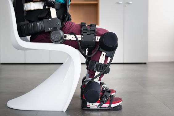 A person sitting using the hank exoskeleton