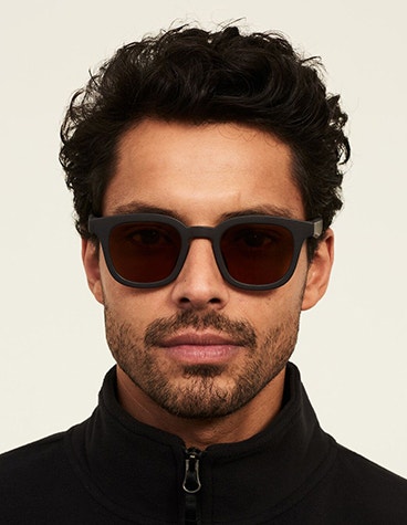 Model wearing the Ace & Tate Benchpress Bobby sunglasses in grey.