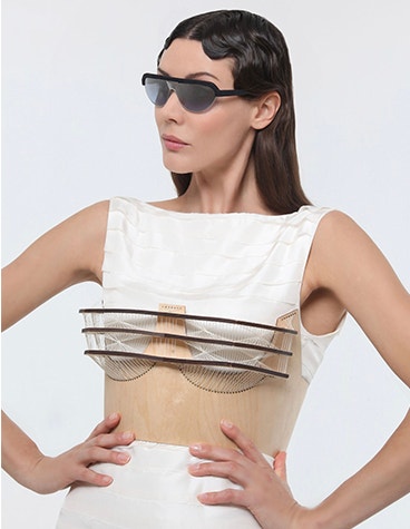 Modelo femenina blanca posando con las manos en las caderas, mirando a un lado mientras lleva gafas de sol Hoet Cabrio