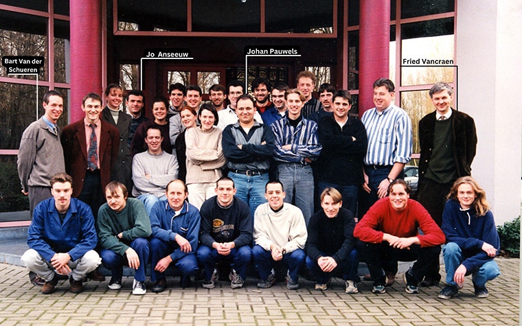 A group photo of Materialise's first set of employees standing outside