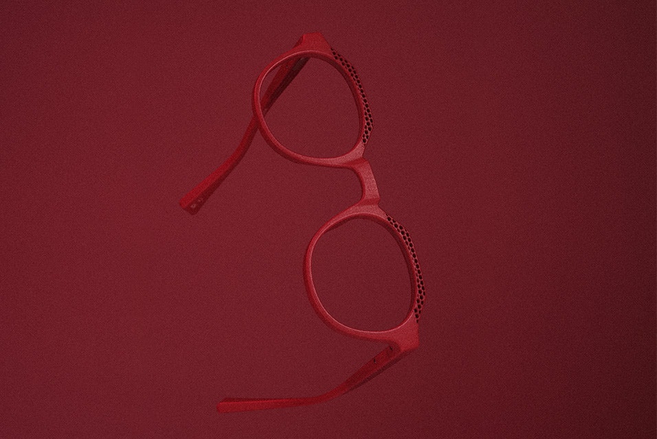 A pair of red 3D-printed Acuitis frames against a red background