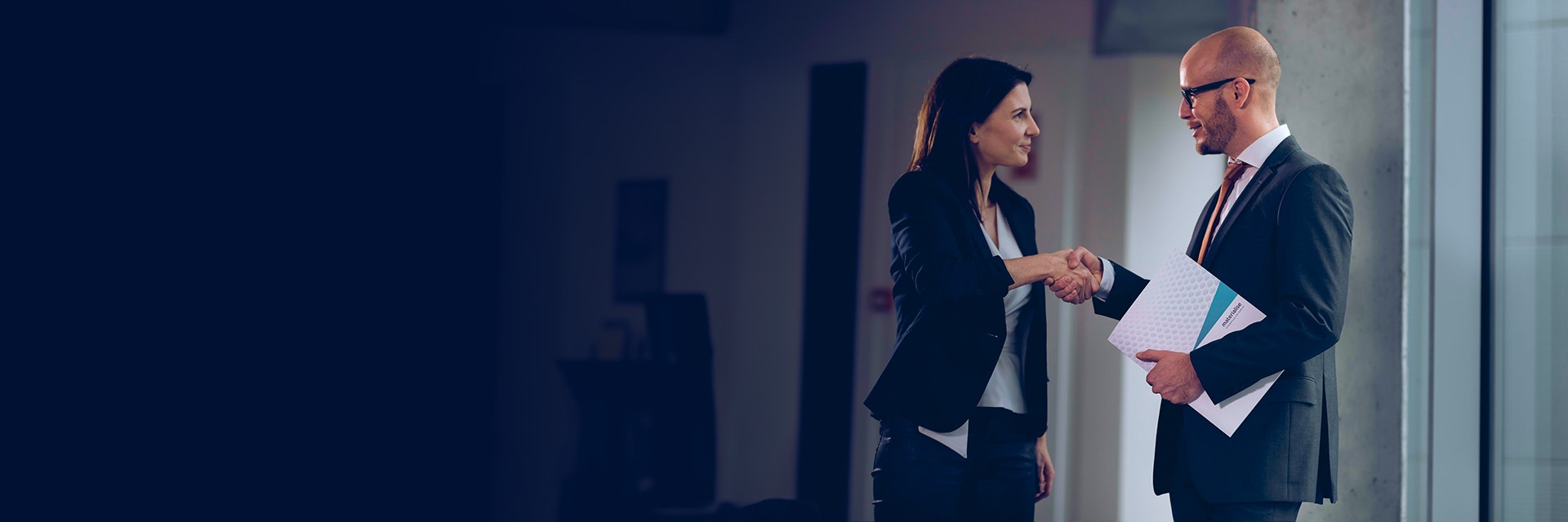 Man and woman talking and smiling while shaking hands