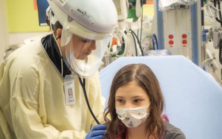 Healthcare employee checking a child with a stethoscope