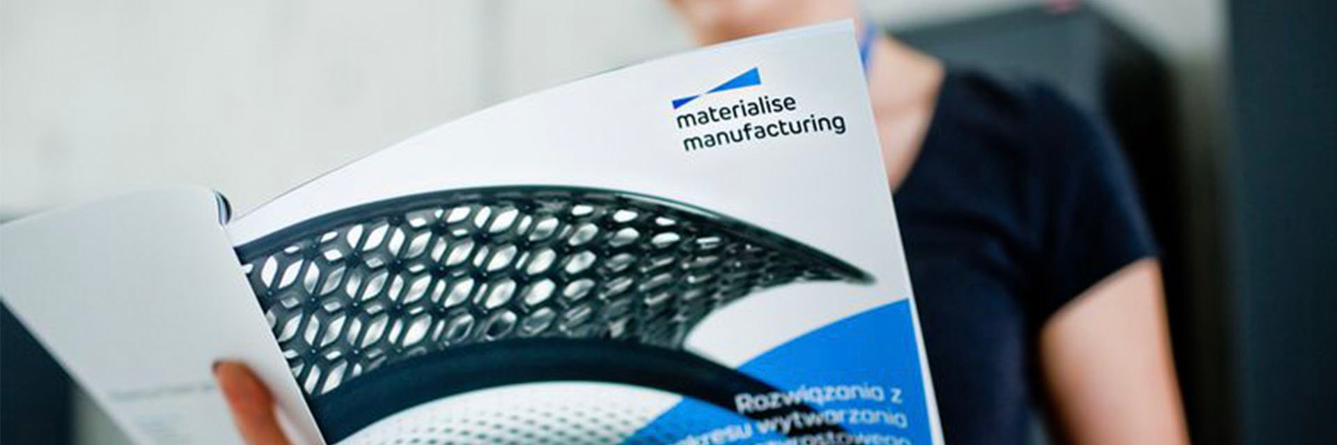 A woman reading a Materialise brochure
