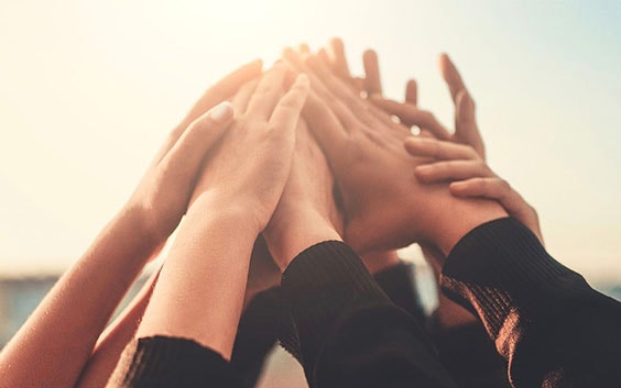 A group of hands raised and touching
