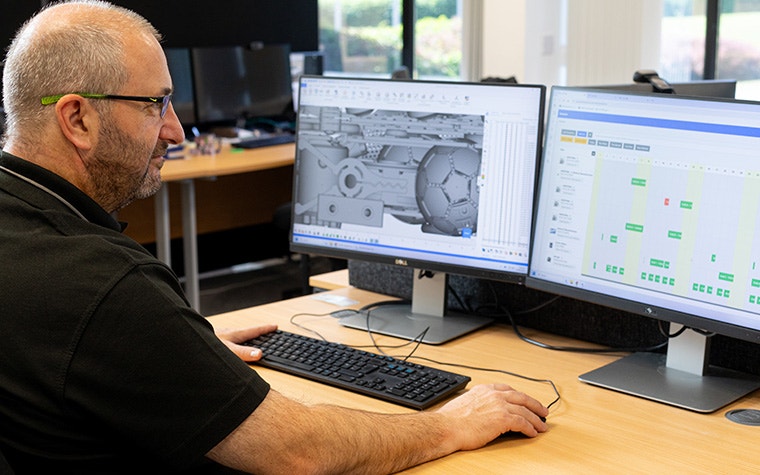 A Ricoh 3D team member looking at additive manufacturing build data on his computer via the CO-AM software ecosystem.