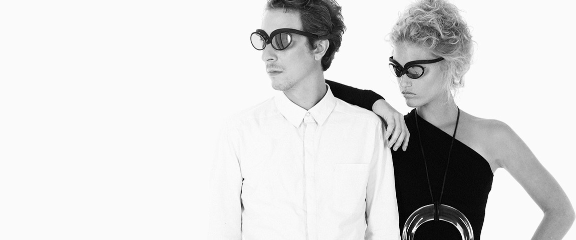 Benjamin Desmet e Stefanie Callebaut del gruppo belga indie pop SX posano insieme, guardando lontano dallo schermo e indossano occhiali Cabrio SX Hoet