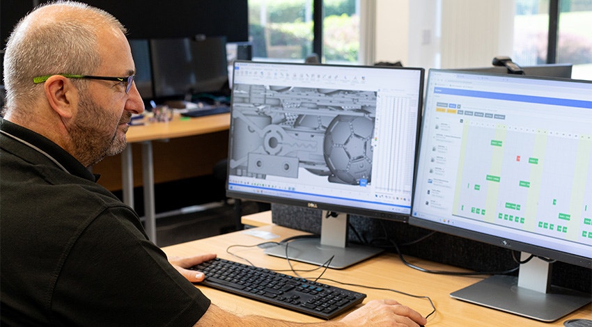 A Ricoh 3D team member looking at additive manufacturing build data on his computer via the CO-AM software ecosystem.
