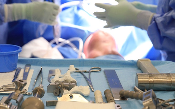 Surgical instruments laid out ready for use in knee surgery on the patient who is lying on the bed in the OR