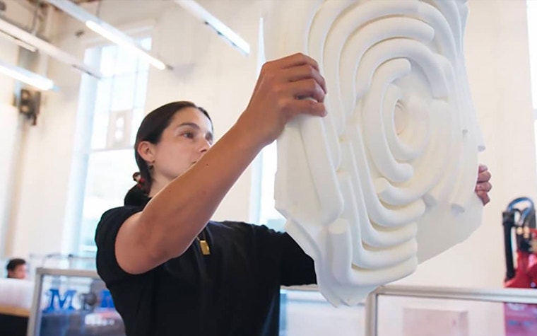 Woman holding up a 3D-printed acoustic panel