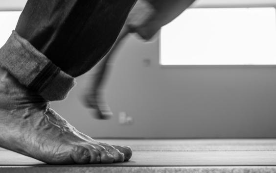 A man walks barefoot over a footscan pressure plate.