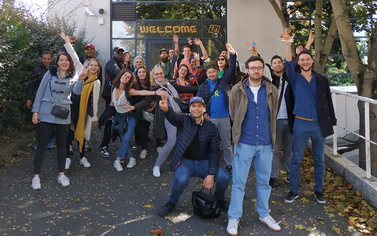 Materialise Paris team smiling and waving in front of the office building