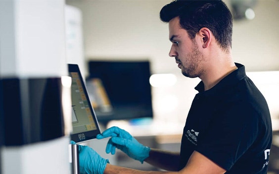 Close-up view of a Materialise employee viewing a screen on an EOS 3D printer