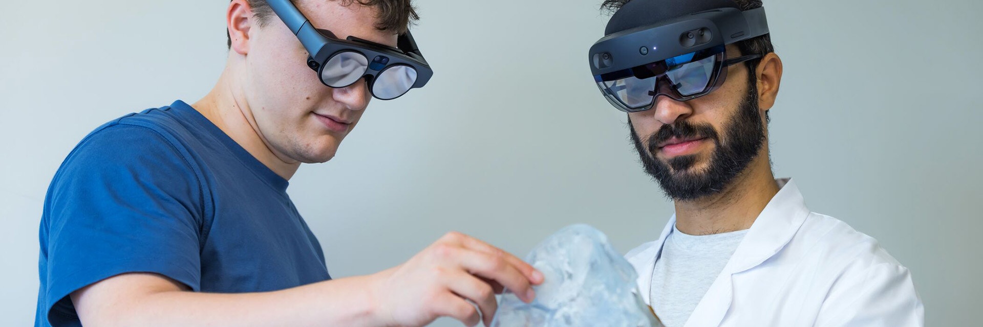 一人はHoloLens、もう一人はMagics LeapのARゴーグルを装着し、解剖模型を見ている二人の男性