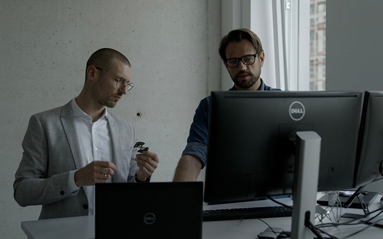 An engineer and a software expert discussing a 3D-printed metal part for Pinarello  