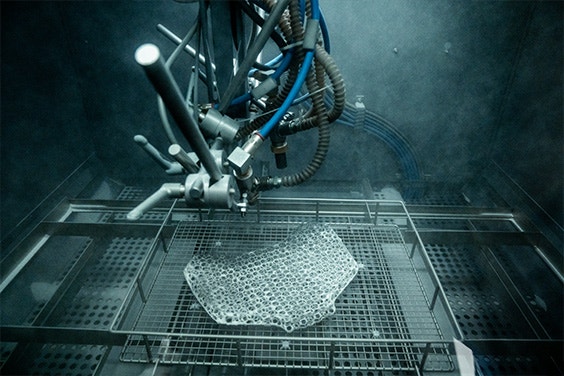 A machine sandblasting a 3D-printed lattice structure