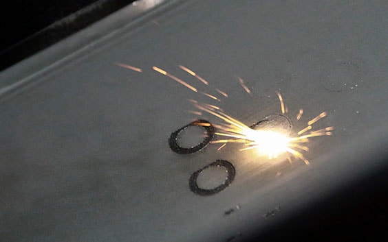 Laser hitting a metal powder bed to 3D print a circlular shape