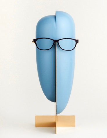 Gerade Ansicht einer schwarzen Yuniku Orgreen-Brille auf einem abstrakten, blauen Schaufensterpuppenkopf