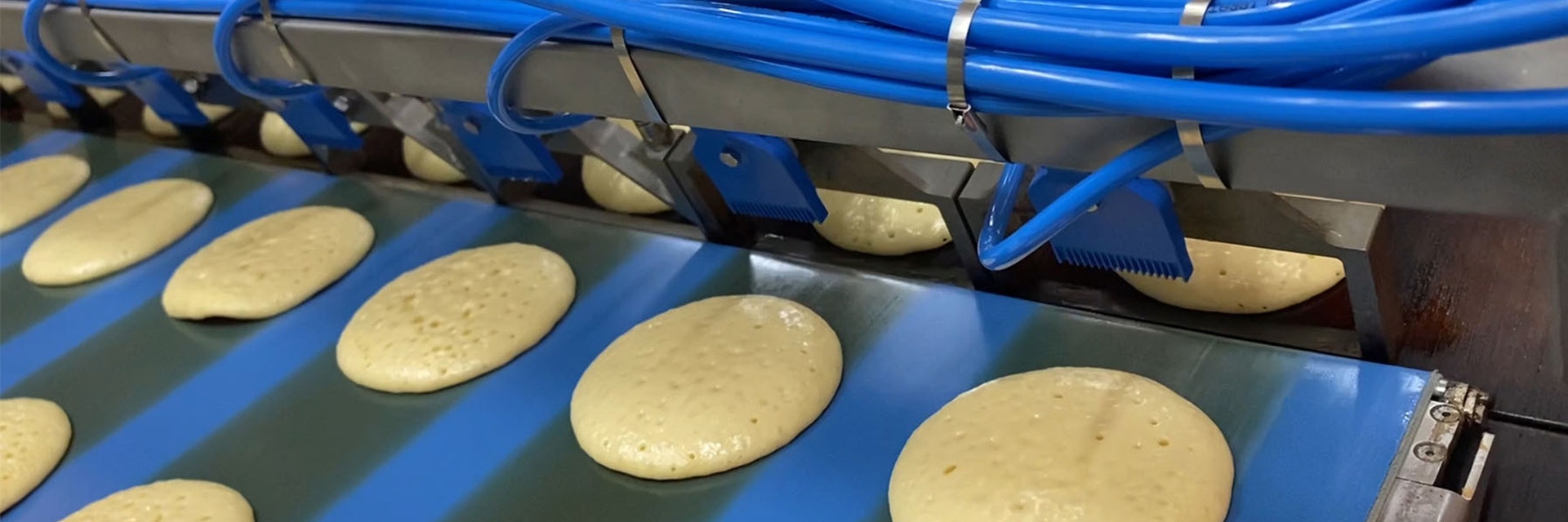 Pancake batter being poured out in a production line